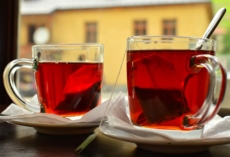 Two cups of hot tea on the table in the window background.の写真素材
