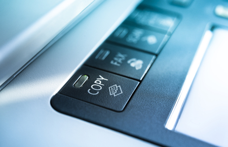 Copy button on a copy machine with blue lightsの写真素材