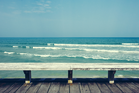 Long wooden chair and sea view の写真素材