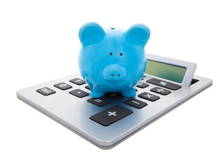 A blue piggy bank sitting on a large calculator.  Conceptual savings. の写真素材