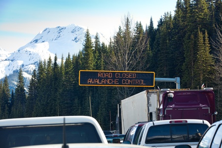 Travel through Roger's Pass in spring.  Traffic is stopped while avalanches are triggered with explosives and then cleaned from the road to ensure safe travel. Roger's Pass, British Columbia, Canada.のeditorial素材