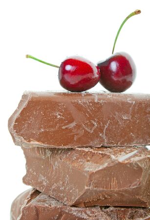 Fresh, deep red cherries on top of thick chunks of milk chocolate   Shot on white background の写真素材