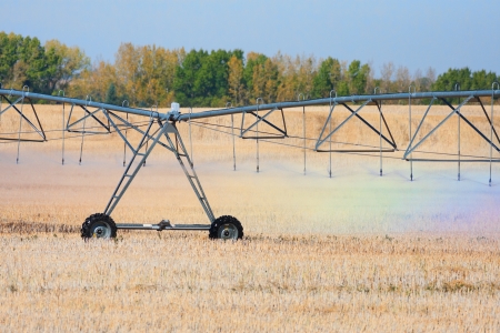 A rainbow of colors are reflected in the water droplets coming from an agricultural watering system pivot の写真素材