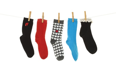 Odd socks whose mates have been lost, hanging on a clothesline   Shot on white background の写真素材