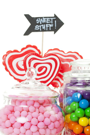 A closeup of part of a candy buffet with a variety of candies in apothecary jars.  Shot on white background.の写真素材
