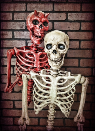 An innocent skeleton with the devil riding on his shoulder trying to tempt him to do something evil.の写真素材