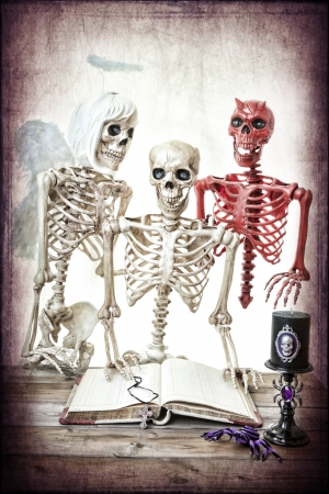 A skeleton man being coaxed by his good and bad side.  Classic good versus evil.の写真素材