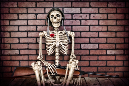 An unknown soldier resting against a brick wall.の写真素材