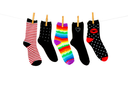 Odd socks whose mates have been lost, hanging on a clothesline.  Shot on white background.の写真素材