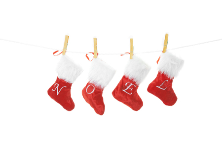 Red velvet Christmas stockings hung on a clothesline, spell noel.  Shot on white background.の写真素材