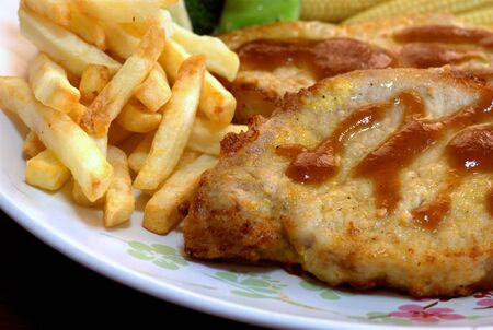The close up shot for the pork steak topped with the brown sauce served with french fried.の写真素材