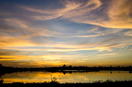 blue  sky and orange sky form sunset on the lakeの写真素材