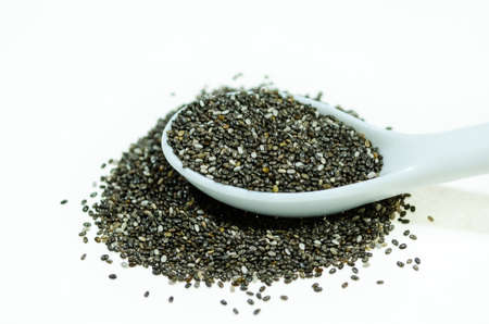 Chia seeds, a healthy source of antioxidants, omega 3 and fiber, are displayed in a porcelain spoonの写真素材
