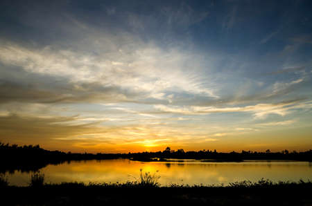 blue  sky and orange sky form sunset on the lakeの写真素材