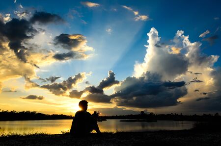 silhouette of female relax on the background of beautiful sunsetの写真素材