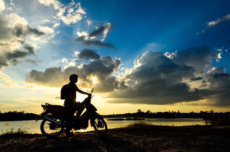 silhouette of female relax on the background of beautiful sunsetの写真素材