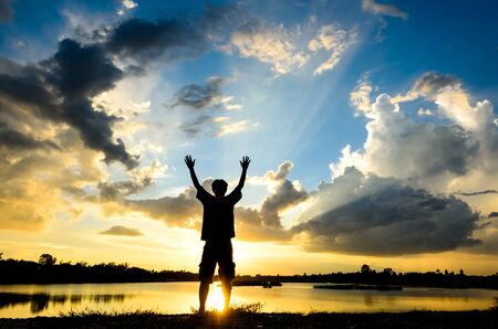 silhouette of female relax on the background of beautiful sunsetの写真素材