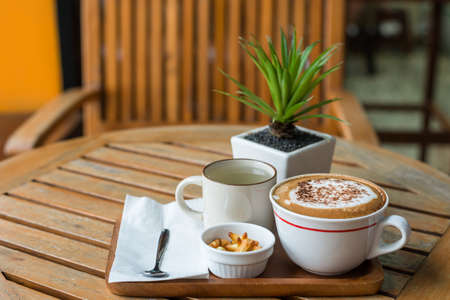 Hot capuchino Coffee in white cup on wooden tableの写真素材