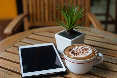 Tablet pc on table desk with coffee cupの写真素材
