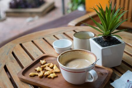 Hot capuchino Coffee in white cup on wooden tableの写真素材
