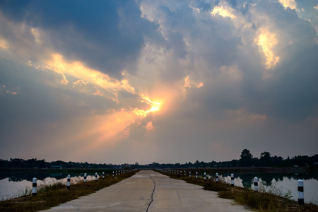 Road under cloudy sky at sunsetの写真素材