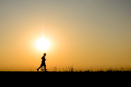 silhouette man jogging on the background of beautiful sunsetの写真素材