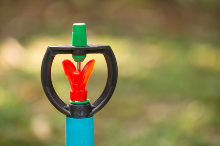 Water sprinkler head in the green gardenの写真素材