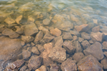 Grey nature stone under water backgroundの写真素材
