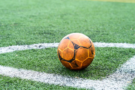 old soccer ball or football ball on coner of  football field