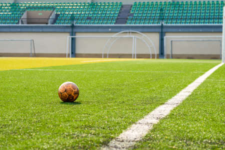 old football on beautiful green grass of football fieldの写真素材