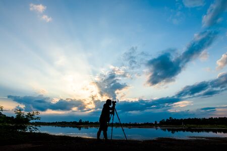 Silhouette of a photographer shooting sunset sceneの写真素材
