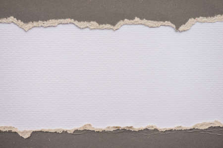 Teared, ripped gray paper on white backgroundの写真素材