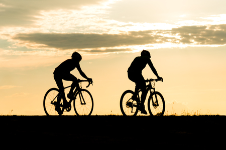 Silhouette of cyclist in motion on the background of beautiful sunsetの写真素材