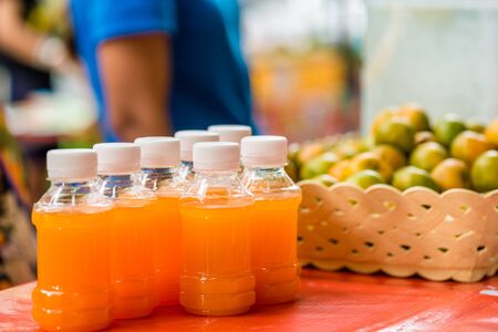 orange juice in plastic bottles for sale on street foodの写真素材
