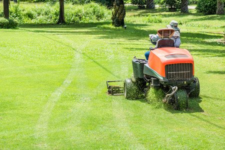 Workers use mower working on the golf courseの写真素材