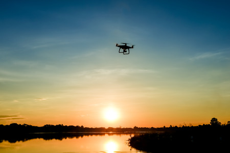 Drone quadcopter with digital camera in flight, Silhouetteの写真素材