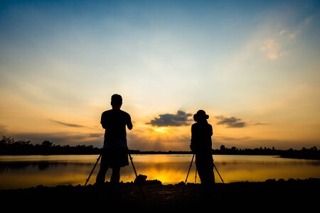 Silhouette of a photographer shooting sunset sceneの写真素材