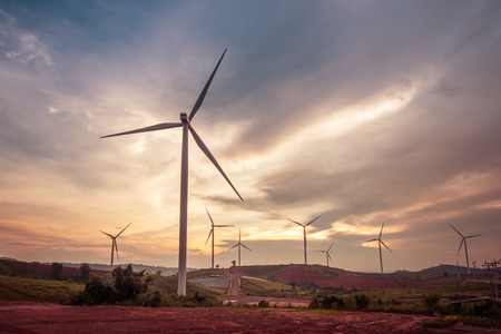 Wind turbine power generators on mountain silhouettes at stormy clouds at sunset. Alternative renewable energy production in Khao Kho Phetchabun Province, Thailandの写真素材