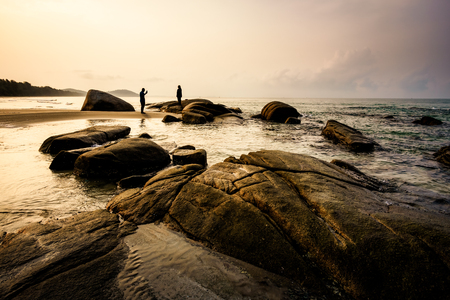The view to the sea and nice sunrise with interesting sky is opened from the coast with rocks. Beautiful summer landscapeの写真素材