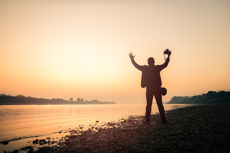 Silhouette photographer at the river on sunrise  background to enjoy colorful skyの写真素材