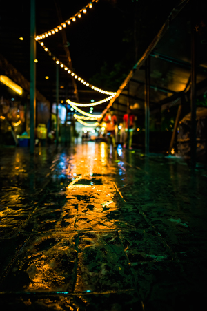 The reflection of the light bulb on the wet footpath, Night city on a rainyの写真素材