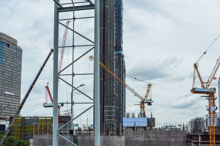 Crane and Building Construction Site under the Rain clouds backgroundの写真素材