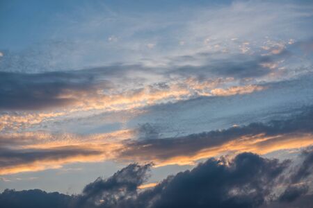 Colorful rain clouds flying on sun setの写真素材