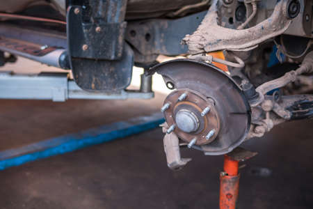 Auto service and maintenance concept - car brake disc at repair station