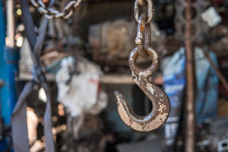 Old hooks and chains in garage with used car spare parts backgroundの写真素材