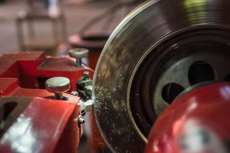Brake lathe tool polishing disc brakes of cars working automatic, Red disk brake machine working to...