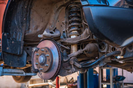 Auto service and maintenance concept - car brake disc at repair station