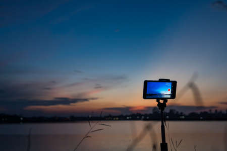 Taking pictures of the sunset landscape by phoneの写真素材