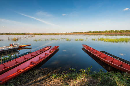 Fishing boat in the lake on blue sky background, Landscape of river in countrysideの写真素材