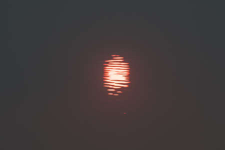 Orange color sky with big sun on sunset use for backgroundの写真素材